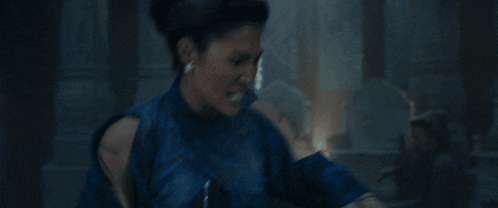 a woman in a blue dress is running away from a man in a black coat .
