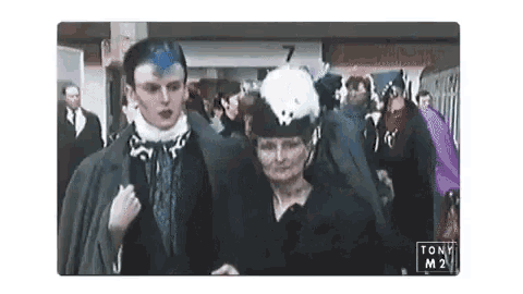 a man and a woman are walking in a crowd with the number 7 in the background .