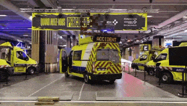 a yellow and white ambulance with the word accident on the back