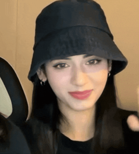 a close up of a woman wearing a black hat that says louis vuitton on it