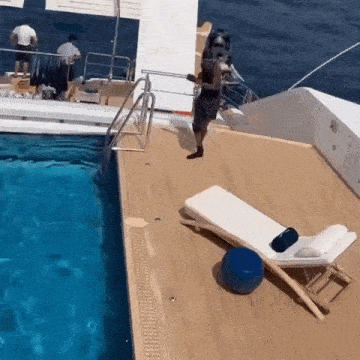 a man is standing on the deck of a boat next to a pool