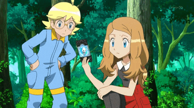 a boy and a girl are standing in a forest and the girl is holding a skull
