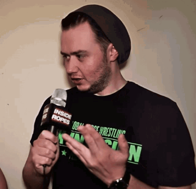 a man wearing a black shirt that says inside ropes on it