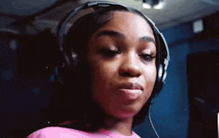 a woman is wearing headphones and making a funny face .