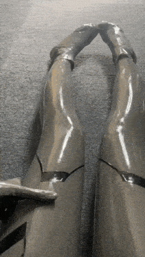 a person wearing a pair of grey latex boots