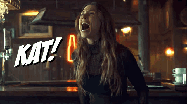 a woman is screaming in front of a neon sign that says kat!