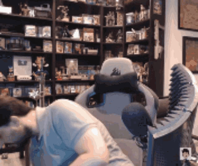 a man sits in a chair with a corsair logo on the back