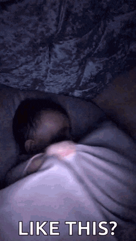 a baby is sleeping in a bed with the words " like this " above it