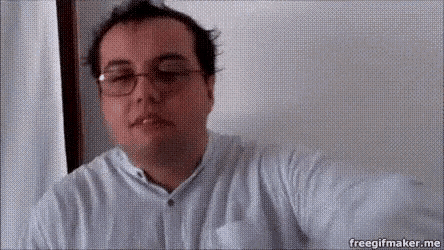 a man wearing glasses and a white shirt looks at the camera with the words freegifmaker.me at the bottom of the screen