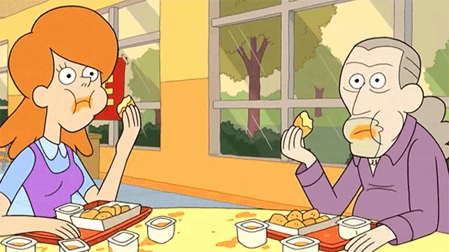a man and a woman are sitting at a table eating food from a tray