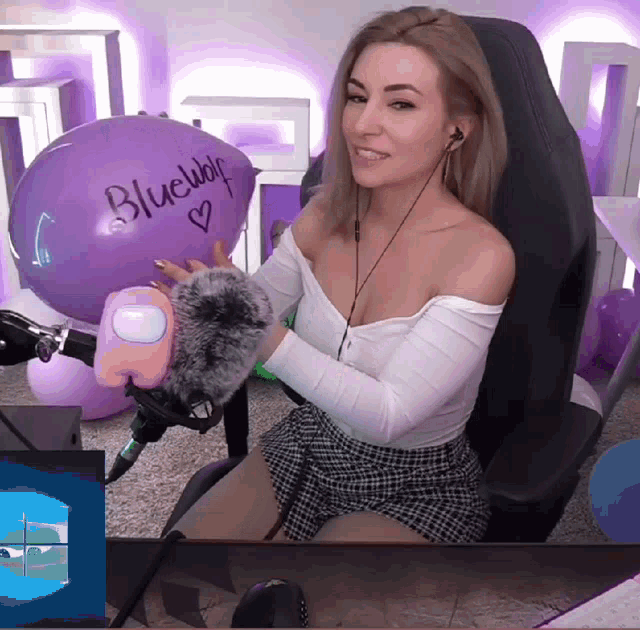 a woman sitting in front of a purple balloon that says " bluewolf "