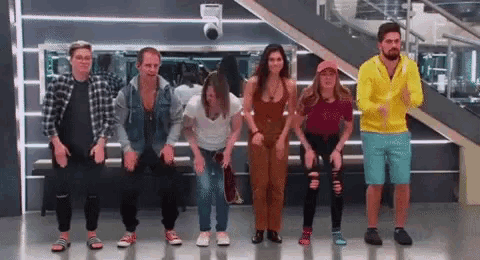 a group of people are standing in a line and dancing