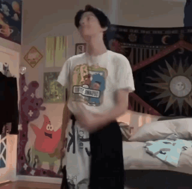 a man in a sesame street shirt is standing in a room