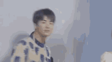 a blurry picture of a man making a peace sign with his hands .