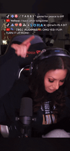 a woman wearing headphones and a shirt that says ' turn it up more ' on it