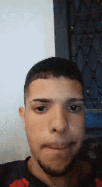 a young man with a beard is making a face