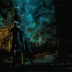 a person is walking through a dark cave with a green light coming out of it .