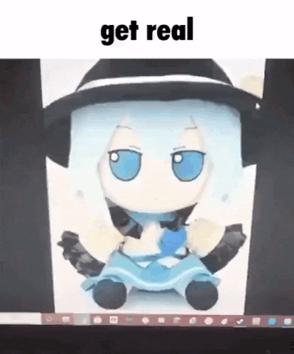 a stuffed doll with blue eyes is sitting in front of a computer screen with the words `` get real '' written on it .