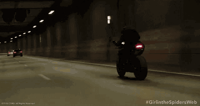 a woman is riding a motorcycle in a dark room .
