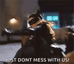 a woman in a catwoman costume is holding a knife and says `` just dont mess with us ! ''
