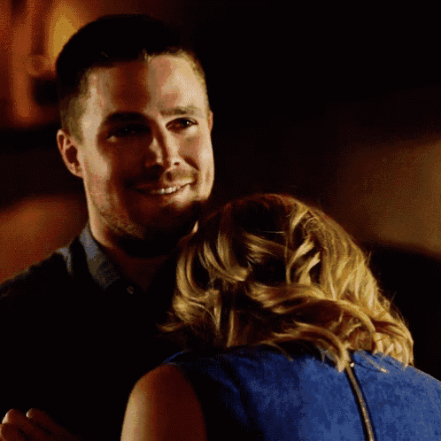 a man and a woman are hugging each other and smiling