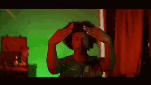 a man with a afro is holding something in his hands