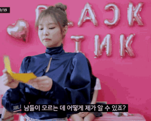 a girl is standing in front of a pink wall with balloons that say black pink