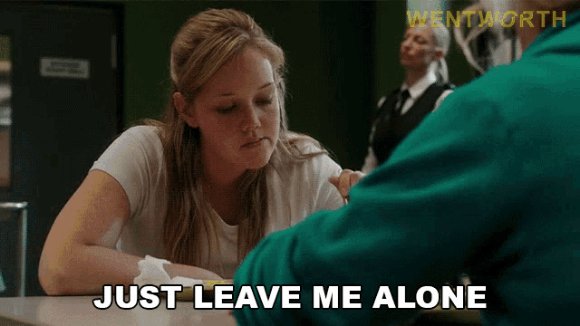 a woman sitting at a table with the words just leave me alone on the bottom