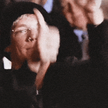 a blurry picture of a man 's face with a woman 's hand on his head