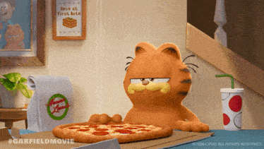 garfield is sitting at a table eating a pizza and drinking a soda