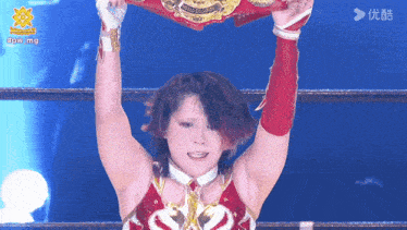a woman in a wrestling ring holds up a belt that says #bowmg on it