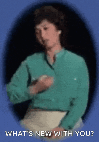 a woman in a green shirt is holding a piece of paper and asking what 's new with you