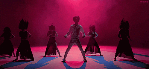 a group of dancers are performing a dance on a stage in front of a red background .