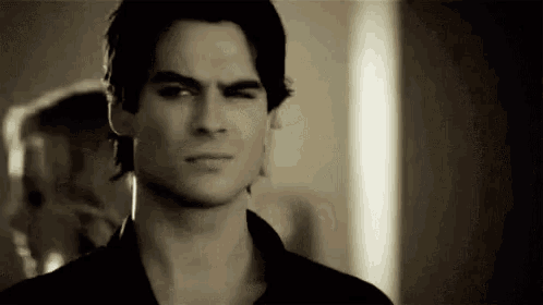 a man in a black shirt is making a funny face and looking at the camera .