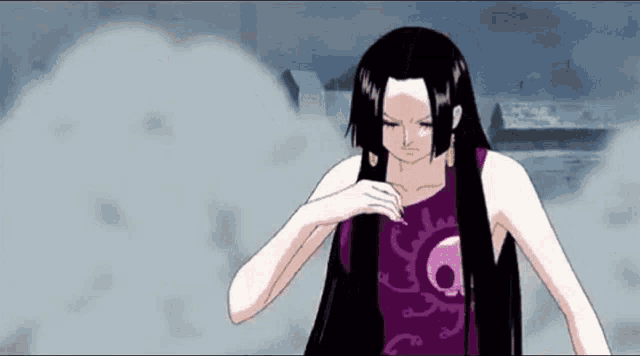 a woman with long black hair is wearing a purple shirt with a skull on it and is standing in the fog .