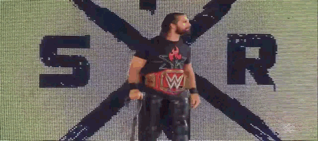 a wrestler stands in front of a screen that says sr