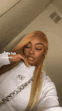 a woman with long blonde hair is taking a selfie with her eyes closed and the hashtag tiktok