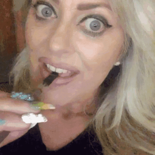 a close up of a woman eating something with a toothpick