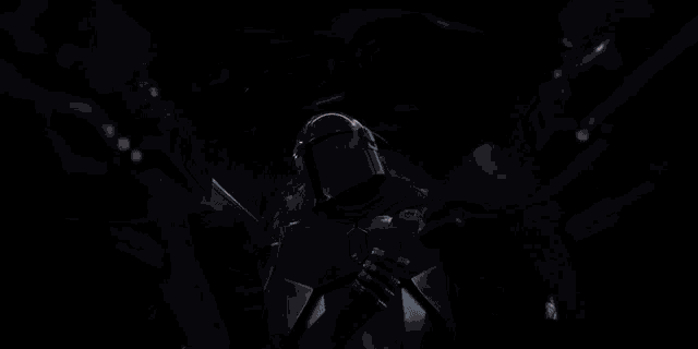 a man with a helmet on is holding a gun in a dark room