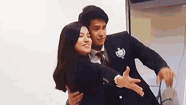 a man and a woman are hugging each other .