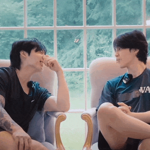 a man wearing a shirt that says wa is sitting next to another man
