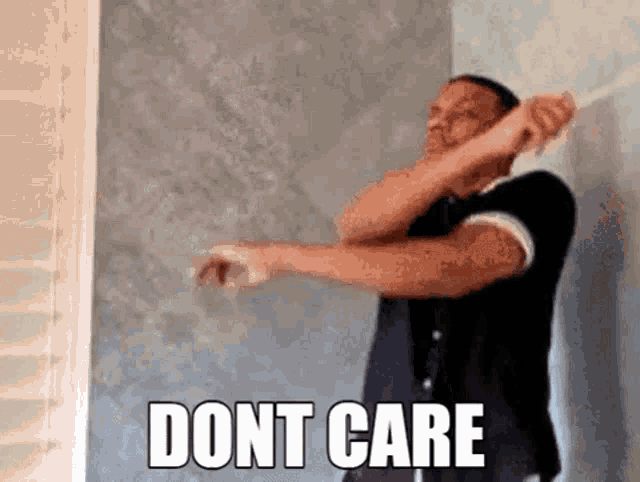 a man is standing in front of a wall with his arms outstretched and the words `` dont care '' written above him .