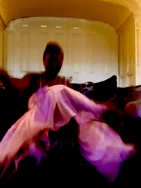 a woman in a purple dress is sitting on a couch
