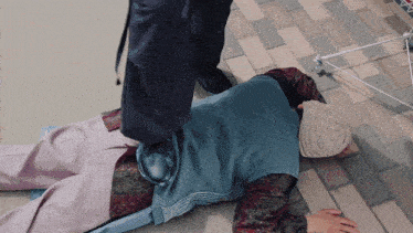 a person laying on the ground with their foot on another person