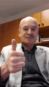 a man with a mustache is giving a thumbs up sign