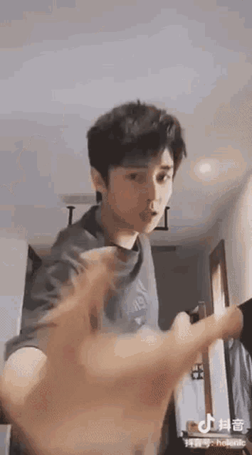 a young man is standing in a room holding a guitar .
