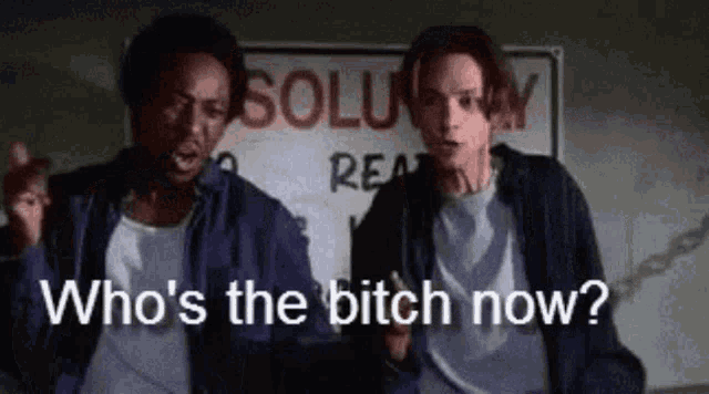 two men are standing next to each other and one of them is asking who 's the bitch now .