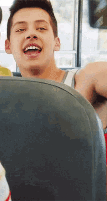 a young boy is sitting on a bus with his mouth open