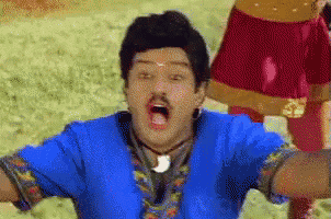 a man in a blue shirt is making a funny face .