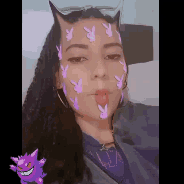 a woman with purple playboy bunny face paint